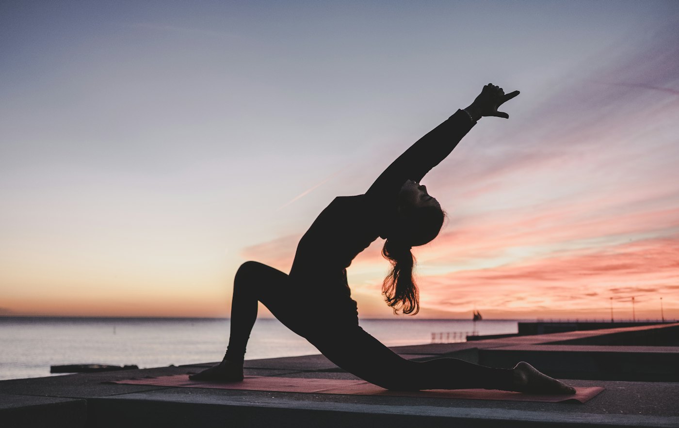 Person stretching outdoors at sunset